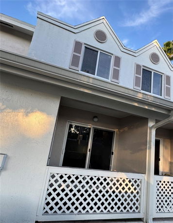 Front view of a house with lattice railing on the balcony.