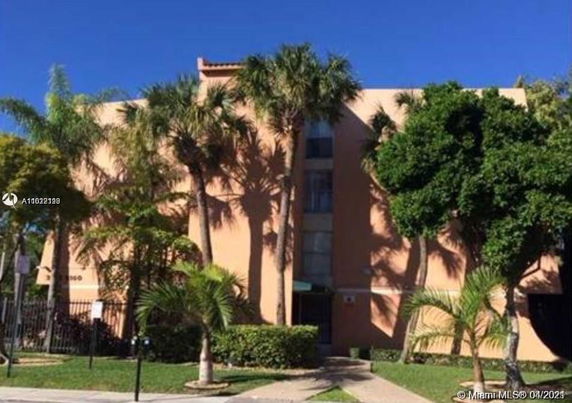 Front view of a multi-story residential building with palm trees.