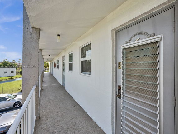 Exterior corridor of a building with a view of the surrounding area.
