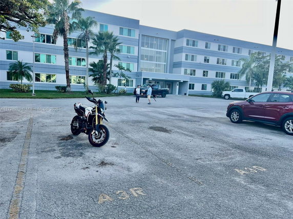 Outdoor parking area in front of a multi-story building.