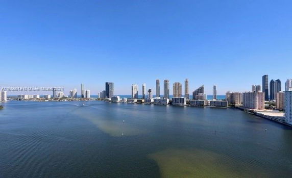 Panoramic view of a city skyline with water in the foreground.