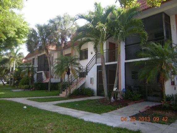 Front view of a two-story residential building with balconies and staircase.