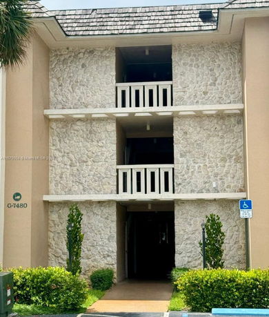 Front view of a multi-story building with stone facade and balconies.