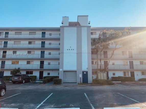 Front view of a multi-story residential building with balconies and vertical architectural elements.