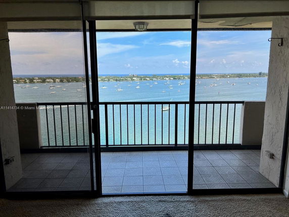 View of surrounding areas with a balcony overlooking water and boats.