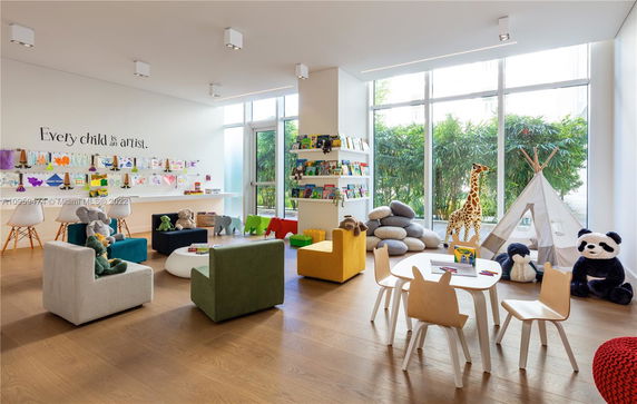 Children's play area with toys, art supplies, and a small tent.