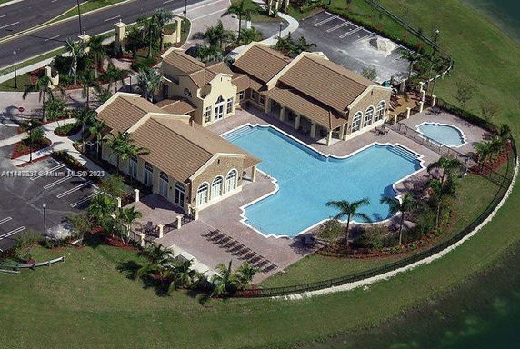 Aerial view of a complex with a large swimming pool and surrounding buildings.