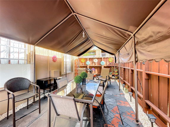 Outdoor covered area with seating and decorative elements.