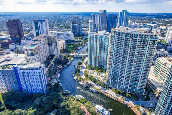 Aerial view of a cityscape with tall buildings and a waterway.