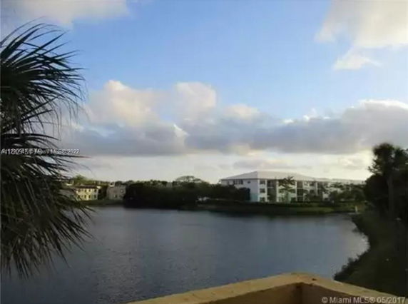 View of a lake with residential buildings in the background.