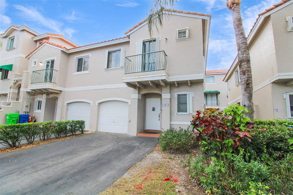 Front view of a two-story house with a double garage and small balcony.