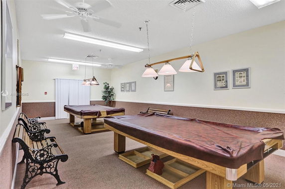 Indoor room with billiards tables and benches.