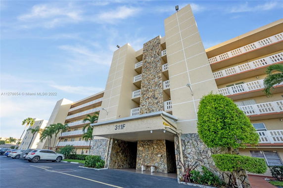 Front view of a multi-story residential building with stone facade accents.