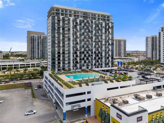 Exterior view of a high-rise building with modern architecture and a rooftop swimming pool.