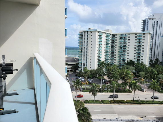 View of surrounding high-rise buildings and a street from a balcony.
