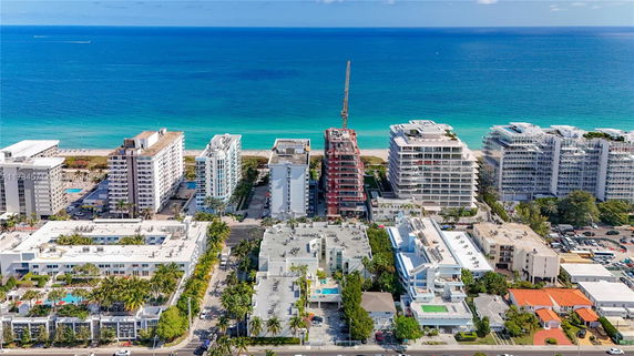 Aerial view of beachfront high-rise buildings and construction near the ocean.