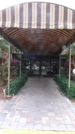 Front entrance of a building with a covered walkway and glass doors.