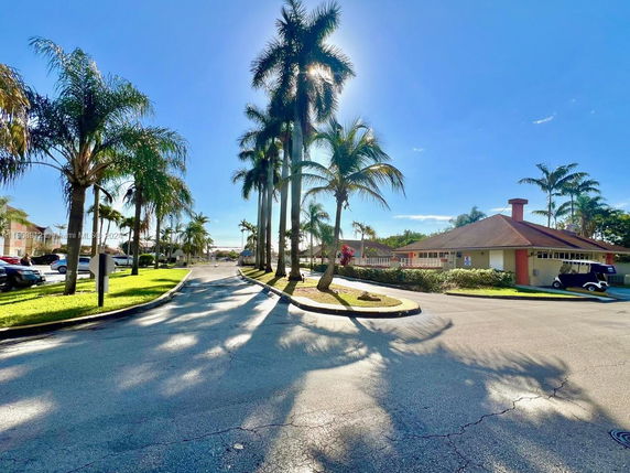 View of a residential area with palm trees and single-story houses.