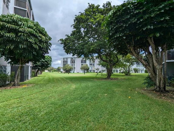 View of apartment buildings with green lawn and trees.