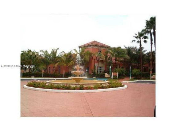 Front view of a building with a fountain in the foreground.