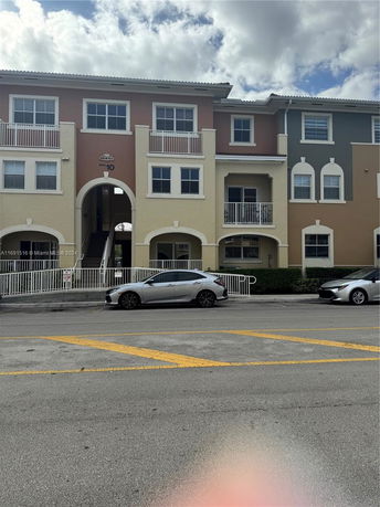 Front view of a multi-story residential building with balconies.