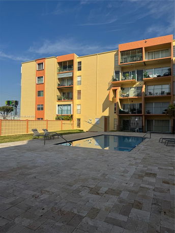 Outdoor view of a multi-story apartment building with a swimming pool area.