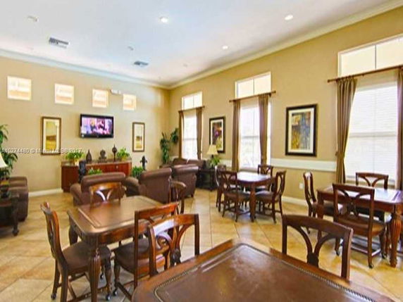 Interior view of a clubhouse with tables, chairs, and a seating area.
