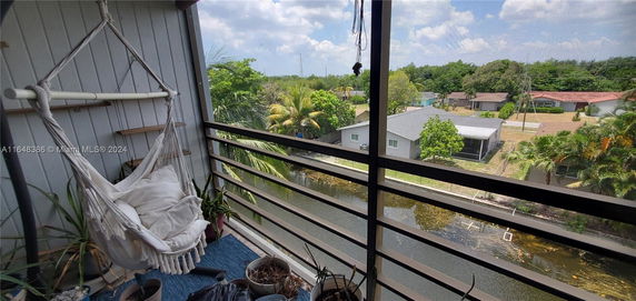Balcony view of residential area with trees and a canal.