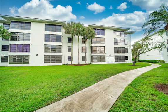 Front view of a multi-story residential building with large windows.