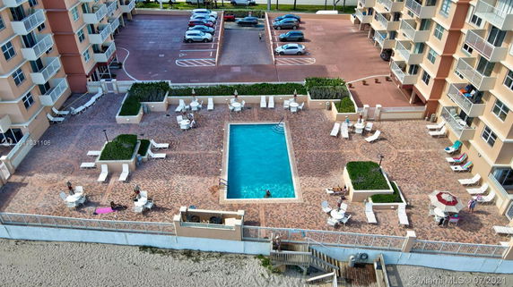 Rooftop view of a building complex featuring a swimming pool and lounging chairs.