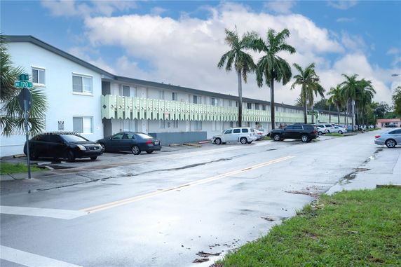 Front view of a two-story apartment building with a parking lot.