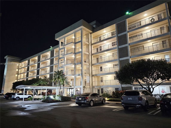 Night view of a multi-story apartment building with balconies.