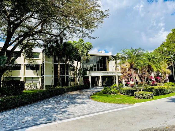Front view of a multi-story building with large windows and landscaping.
