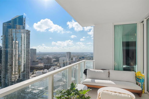 Panoramic view from a balcony overlooking a city skyline and clear sky.