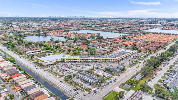 Aerial panoramic view of residential and commercial areas with lakes and roads.