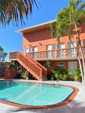 Front view of a two-story house with an outdoor swimming pool.