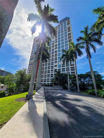 Front view of a tall residential building with a modern glass facade.
