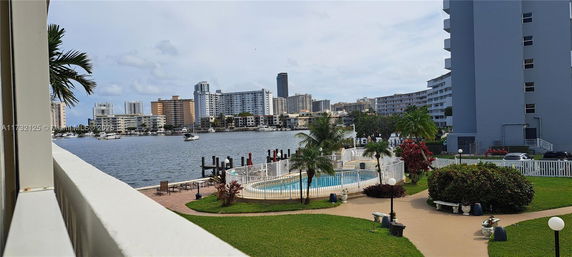 View of high-rise buildings and a swimming pool near a body of water.