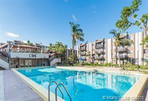 View of a swimming pool in front of a multi-story residential building.