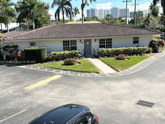 Front view of a single-story building with a tiled roof and landscaped entrance.