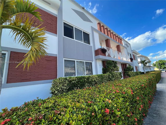 Front view of a multi-story building with brick and white facade.