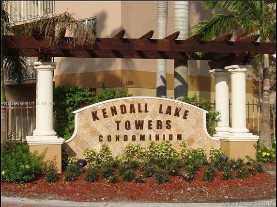Front view of Kendall Lake Towers Condominium entrance sign with columns and decorative pergola.