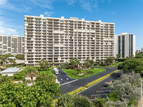 Front view of a multi-story residential building with numerous balconies.