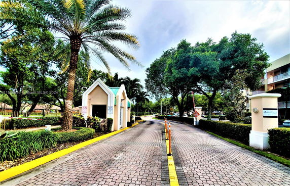 Entrance view of a gated community with a guardhouse.