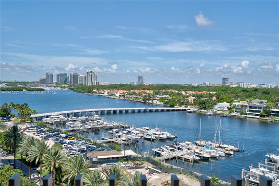 Panoramic view showing a marina with boats and high-rise buildings in the background.