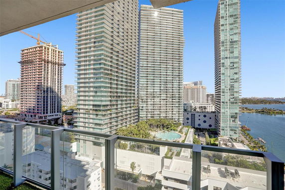 View of multiple high-rise buildings and a nearby water body seen from an elevated position.