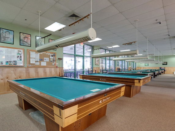 Indoor recreation area with multiple billiards tables.