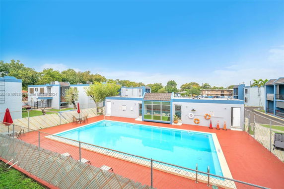 Outdoor swimming pool area with surrounding buildings.