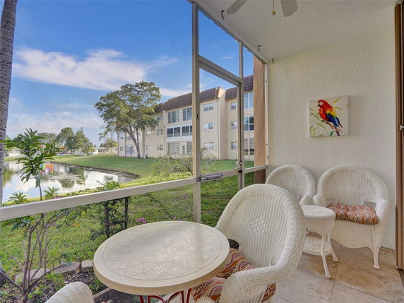 View from a balcony overlooking a small pond and surrounding residential buildings.