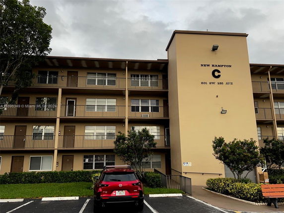 Front view of a multi-story apartment building with balconies.